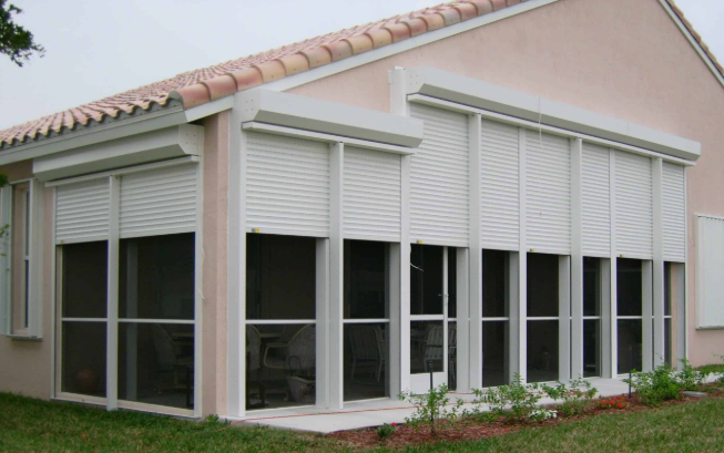A house with a screened in porch and shutters on the windows.