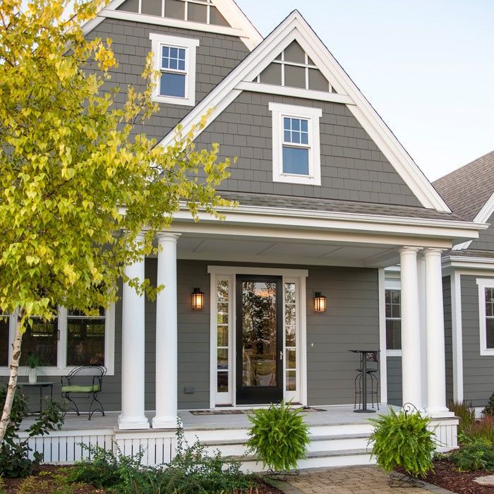 A gray house with white trim and a porch