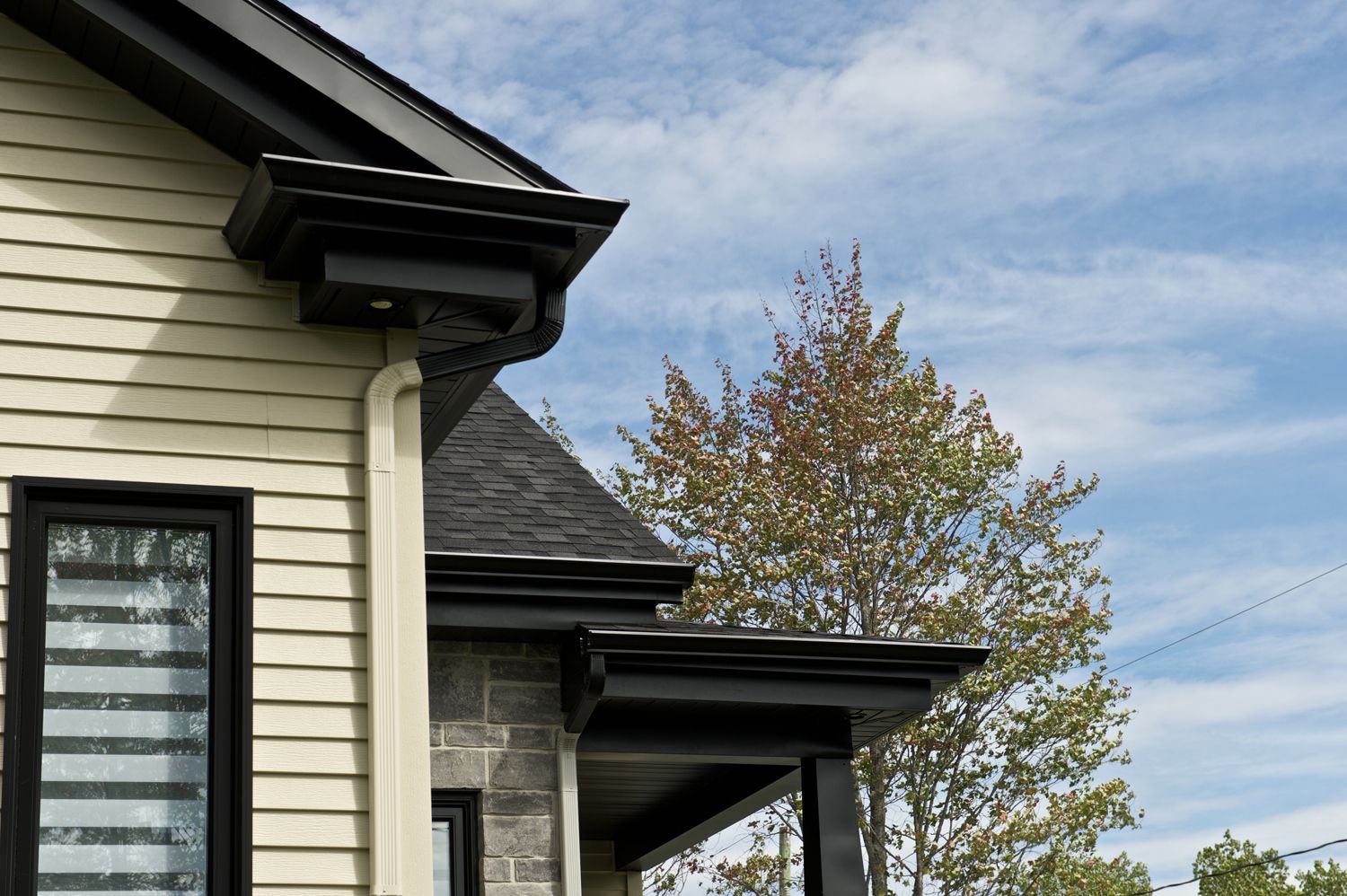 The side of a house with a porch and a window.
