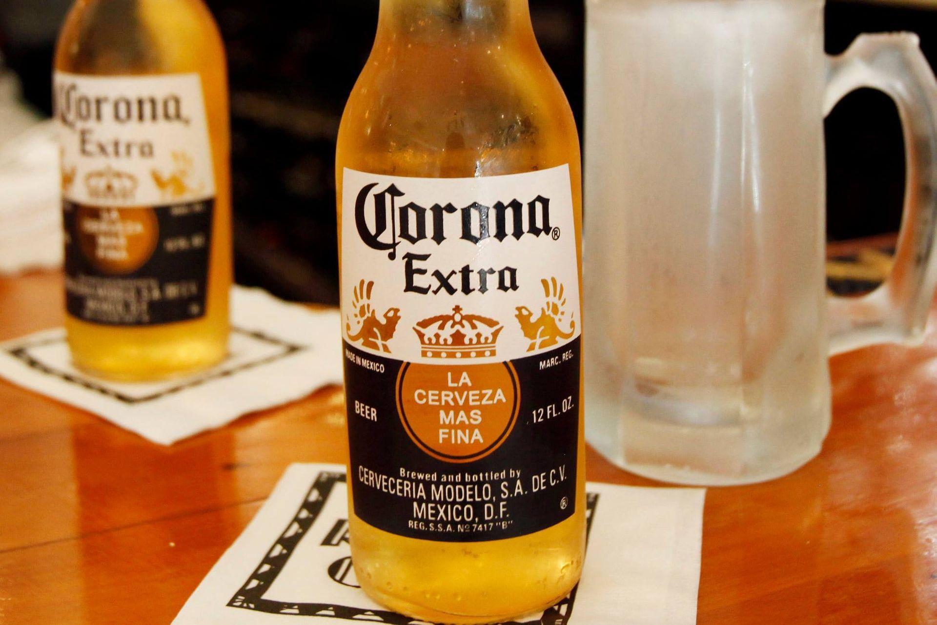 A bottle of corona extra beer sits on a table