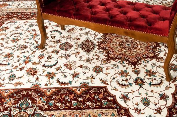 Red velvet bench on ornate cream and burgundy floral rug.