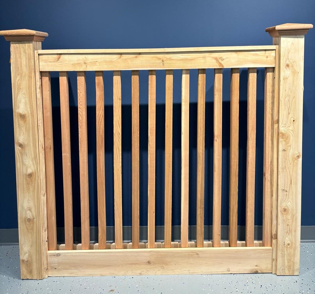 A wooden railing is against a blue wall