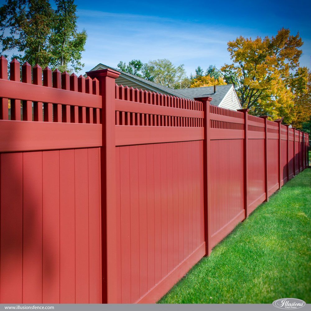 A red fence with a house in the background