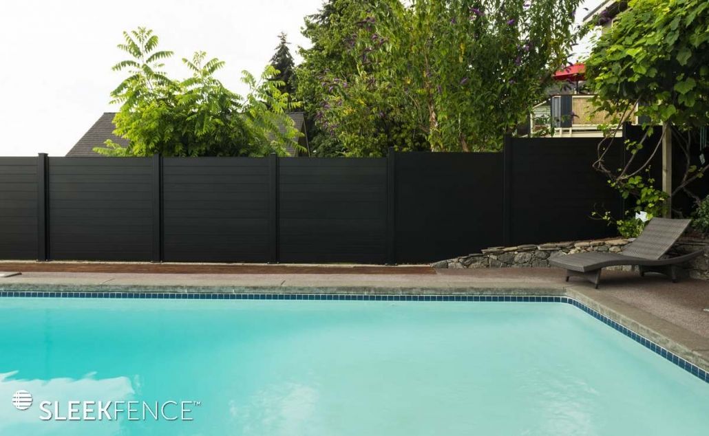 A swimming pool with a black fence surrounding it.