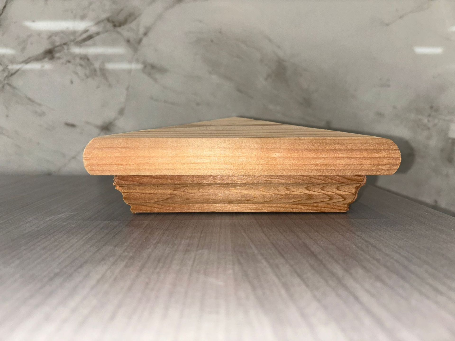 A piece of wood is sitting on top of a wooden table.