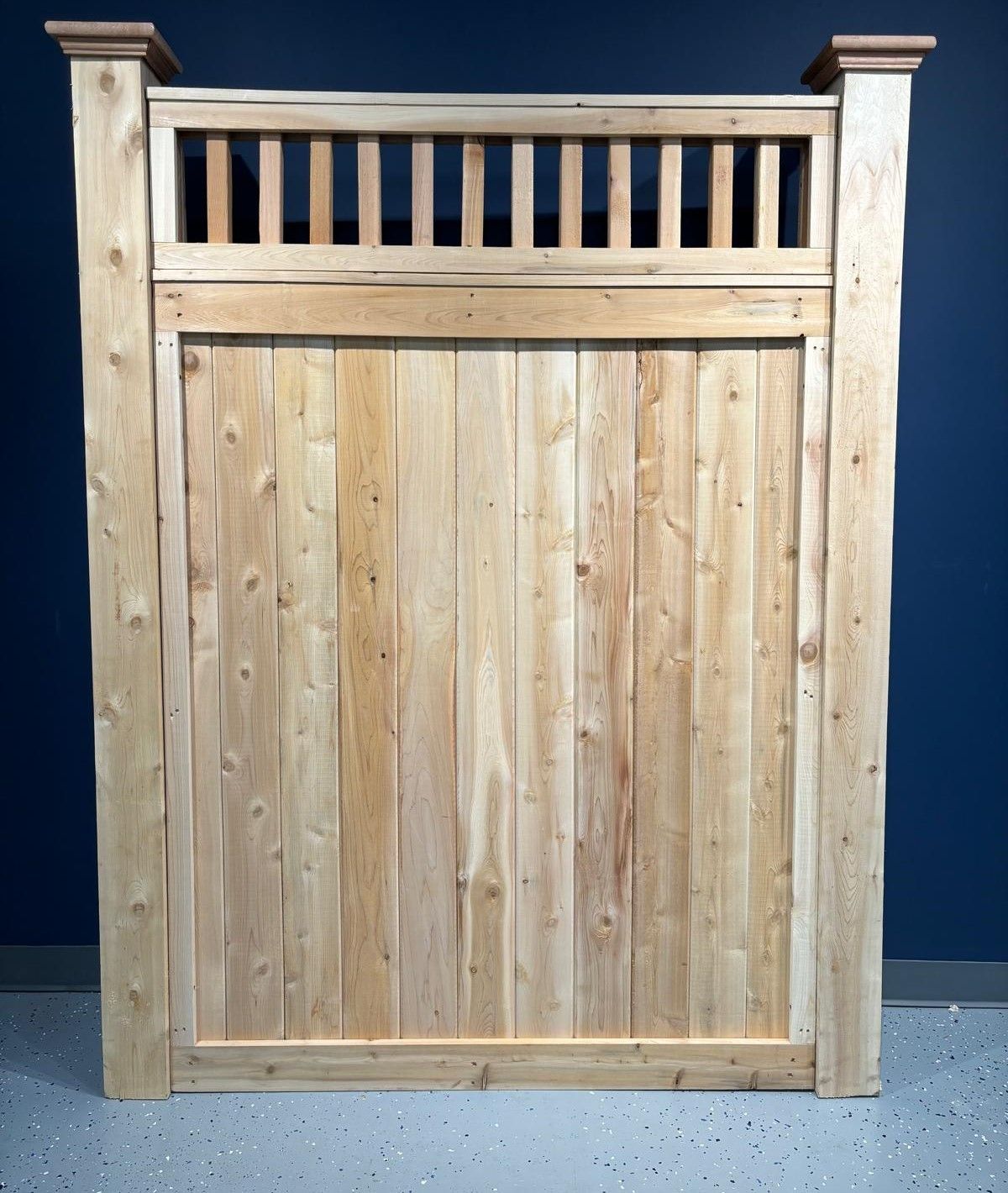 A wooden fence with a blue wall in the background