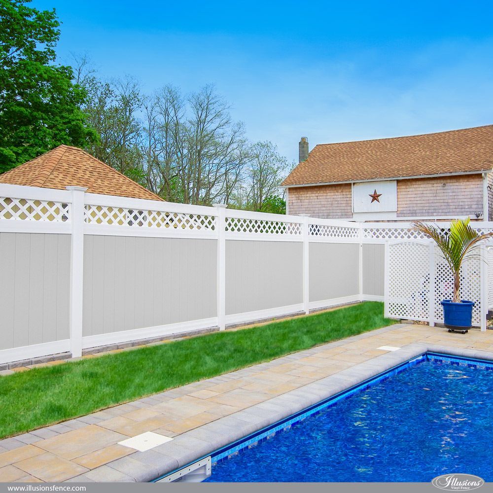 A white fence surrounds a swimming pool in a backyard