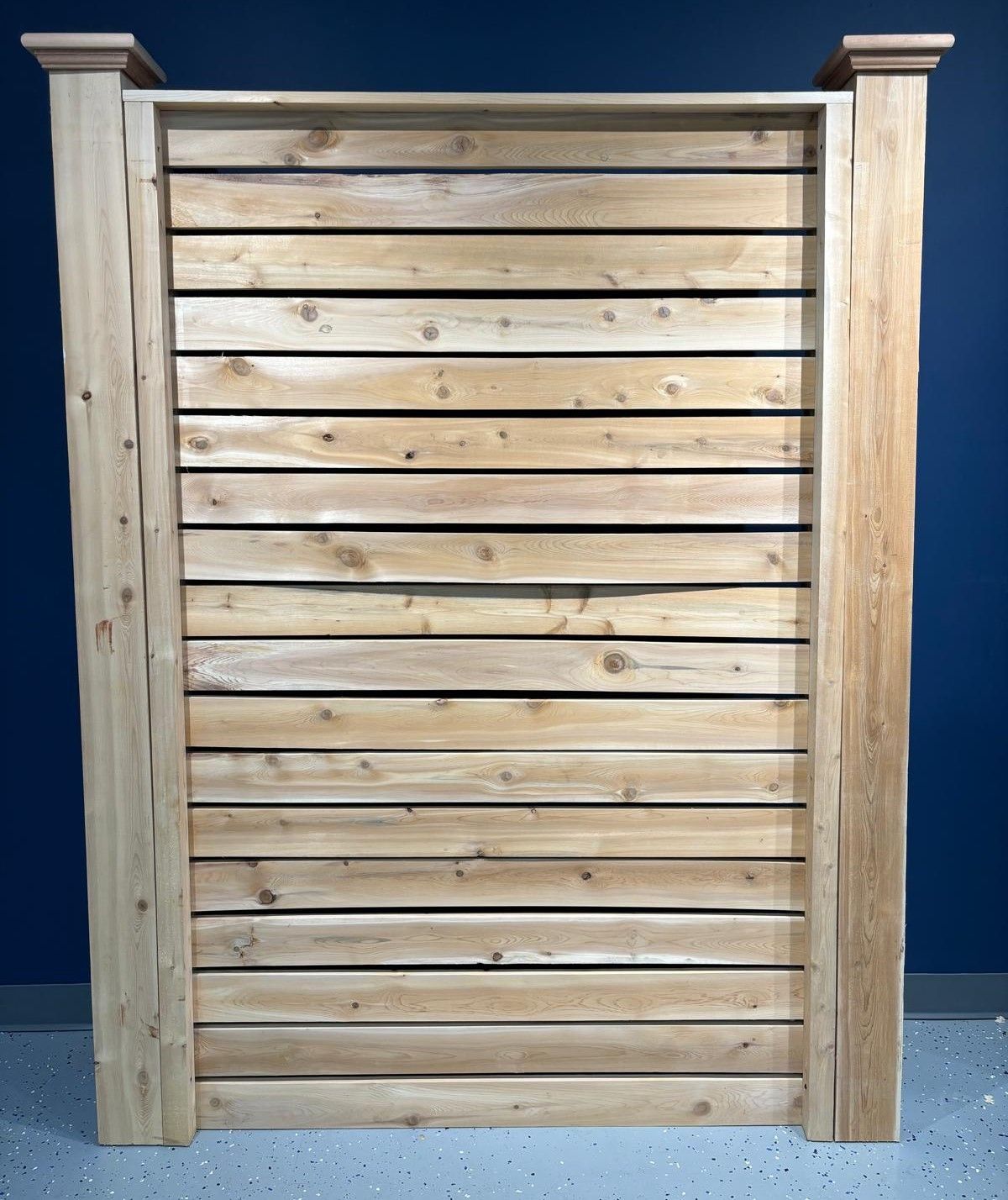 A wooden fence with a blue wall in the background