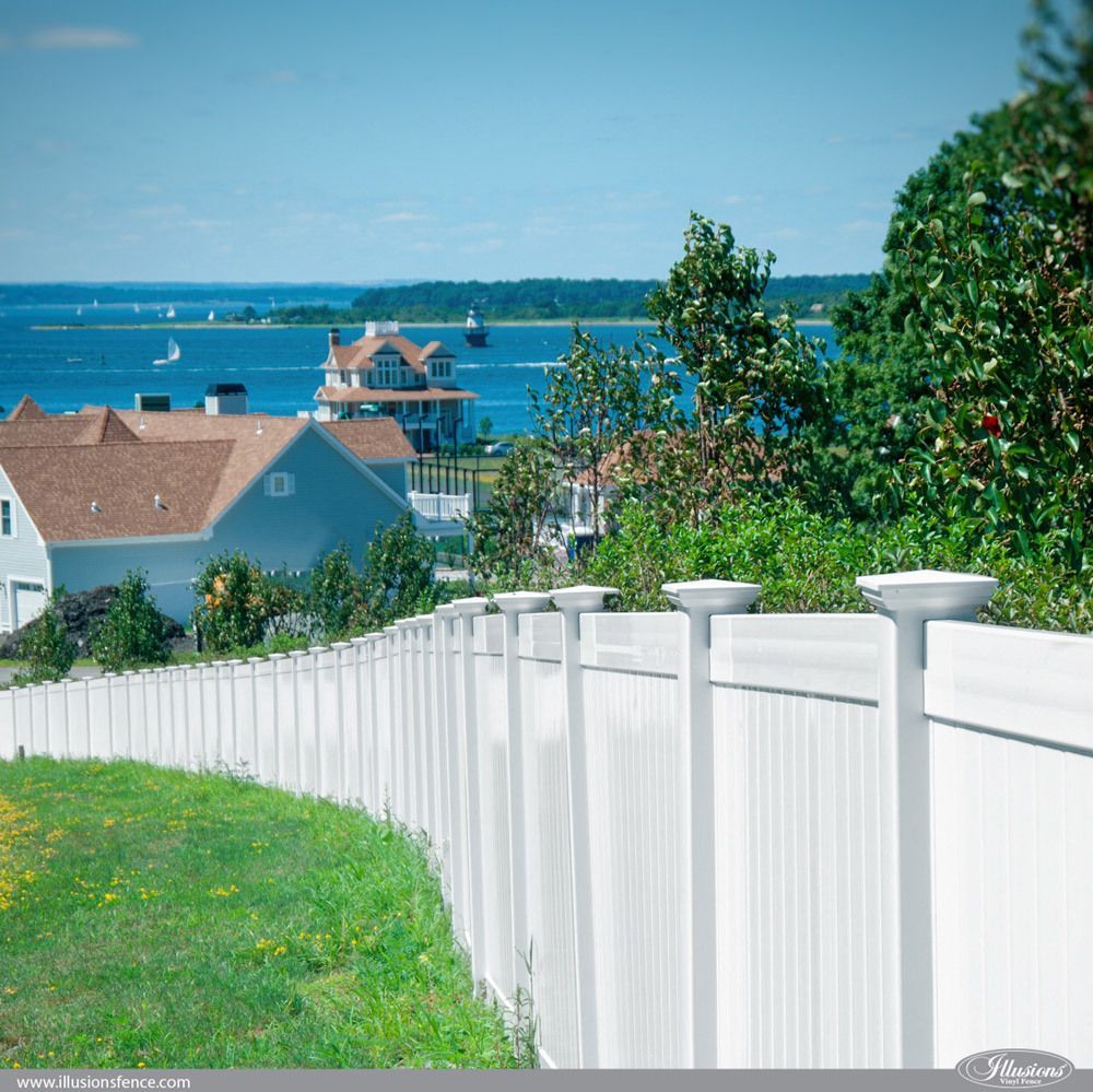A white fence with a view of the ocean