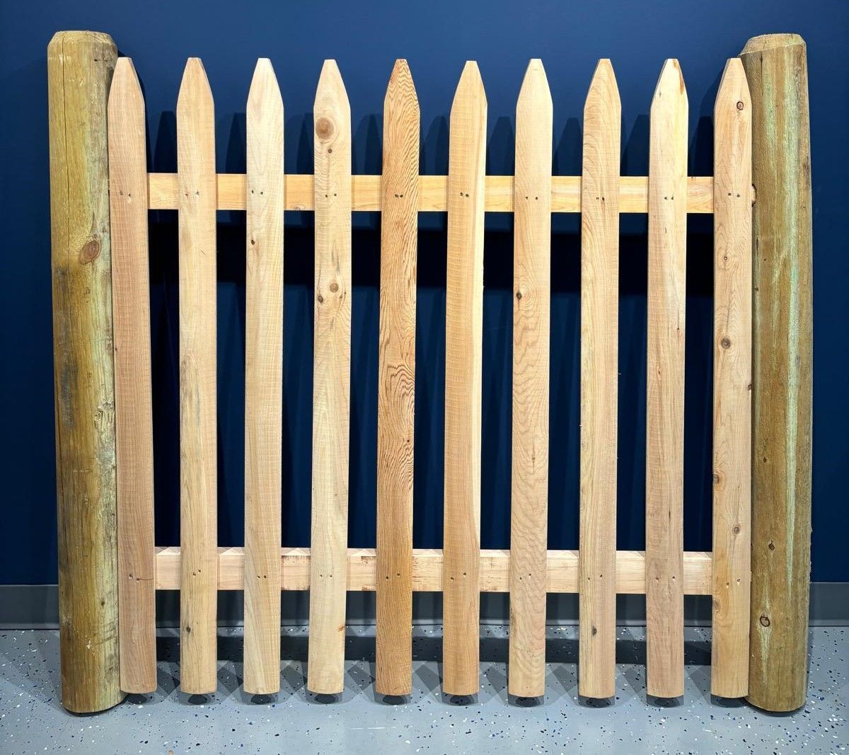 A wooden picket fence with a blue background