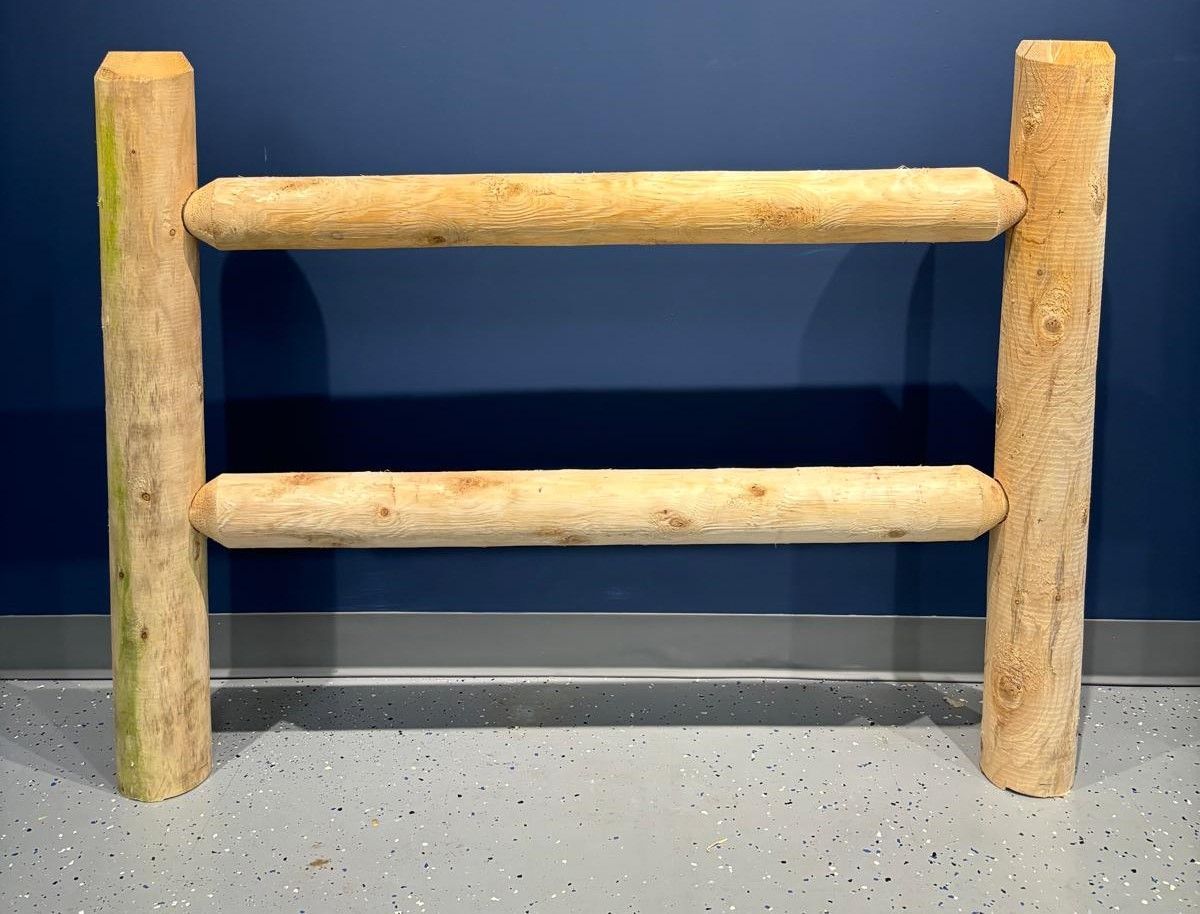 A wooden fence is sitting on the floor in front of a blue wall.