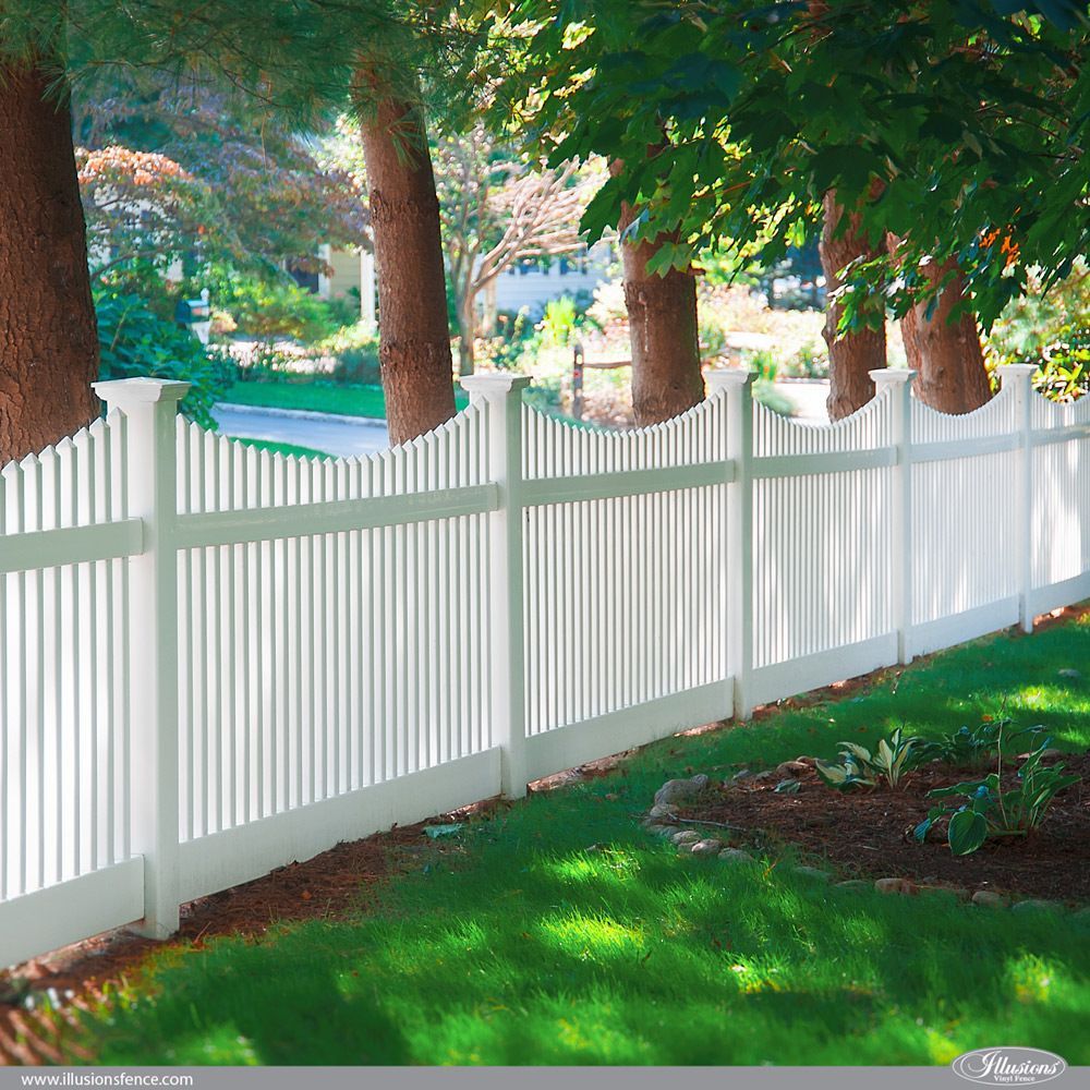A white picket fence surrounds a lush green yard