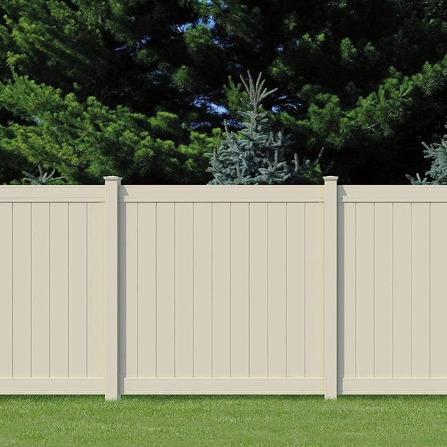 A white fence is sitting on top of a lush green lawn.