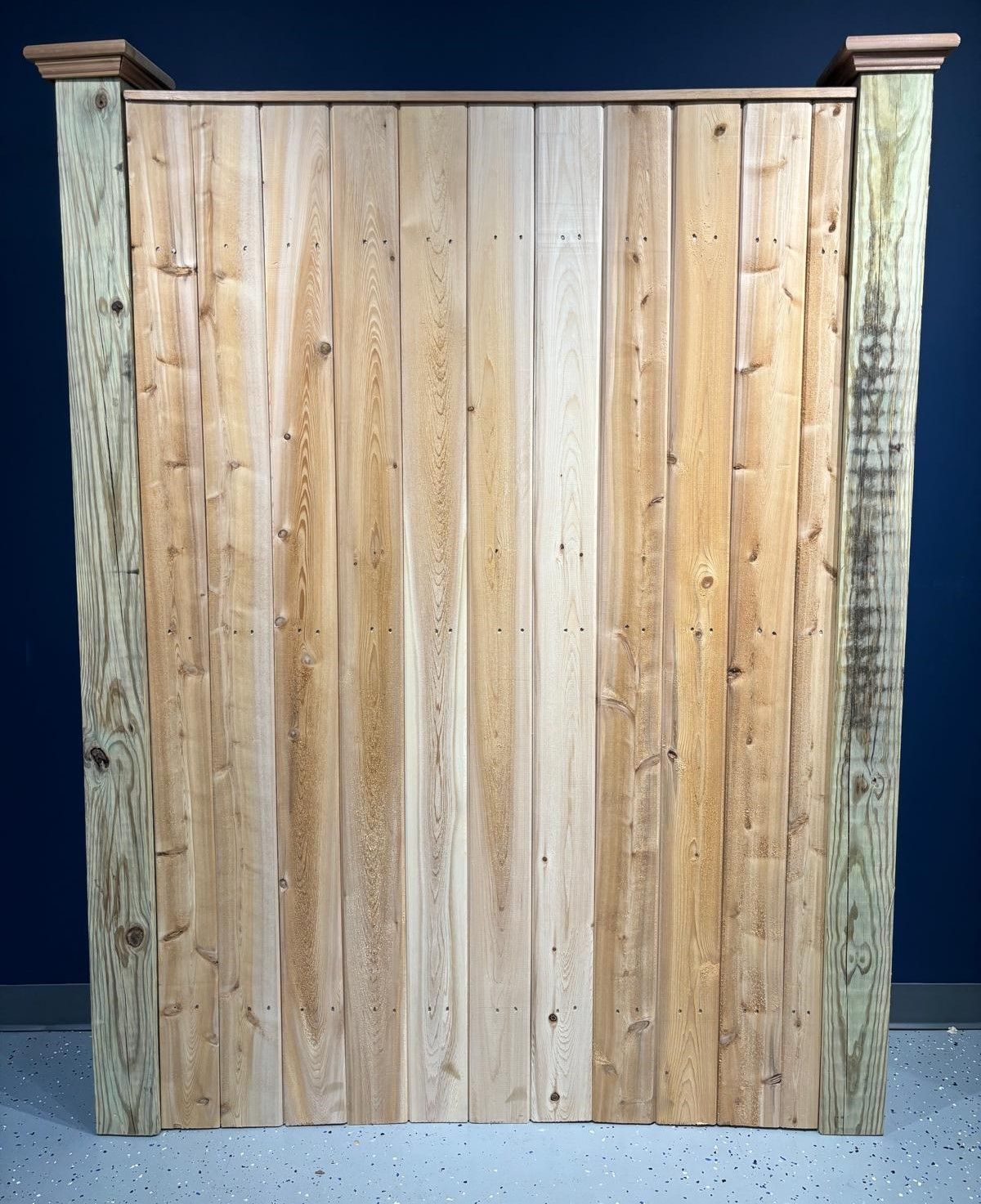 A wooden fence with a blue wall in the background