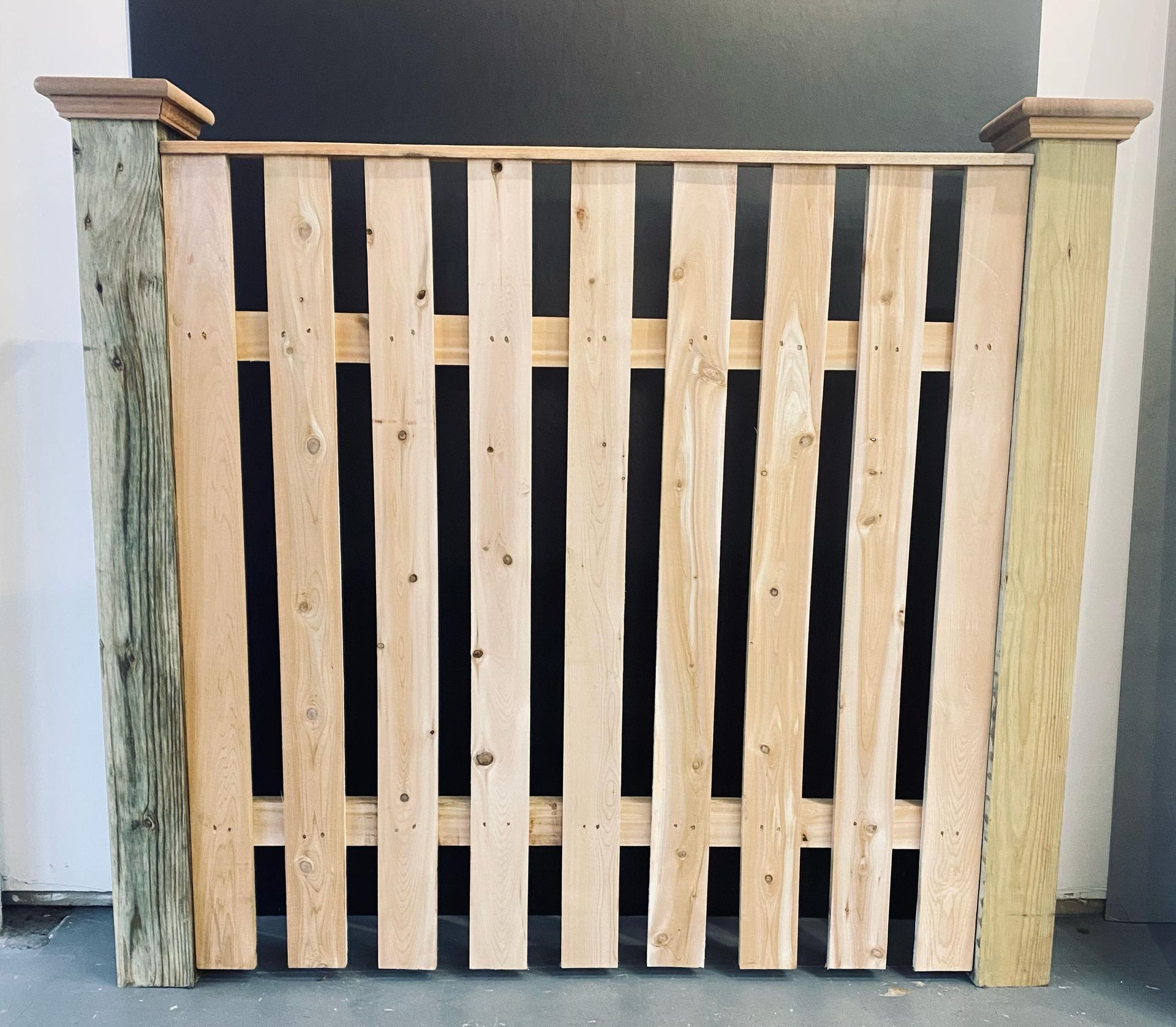 A wooden fence is sitting on a concrete floor