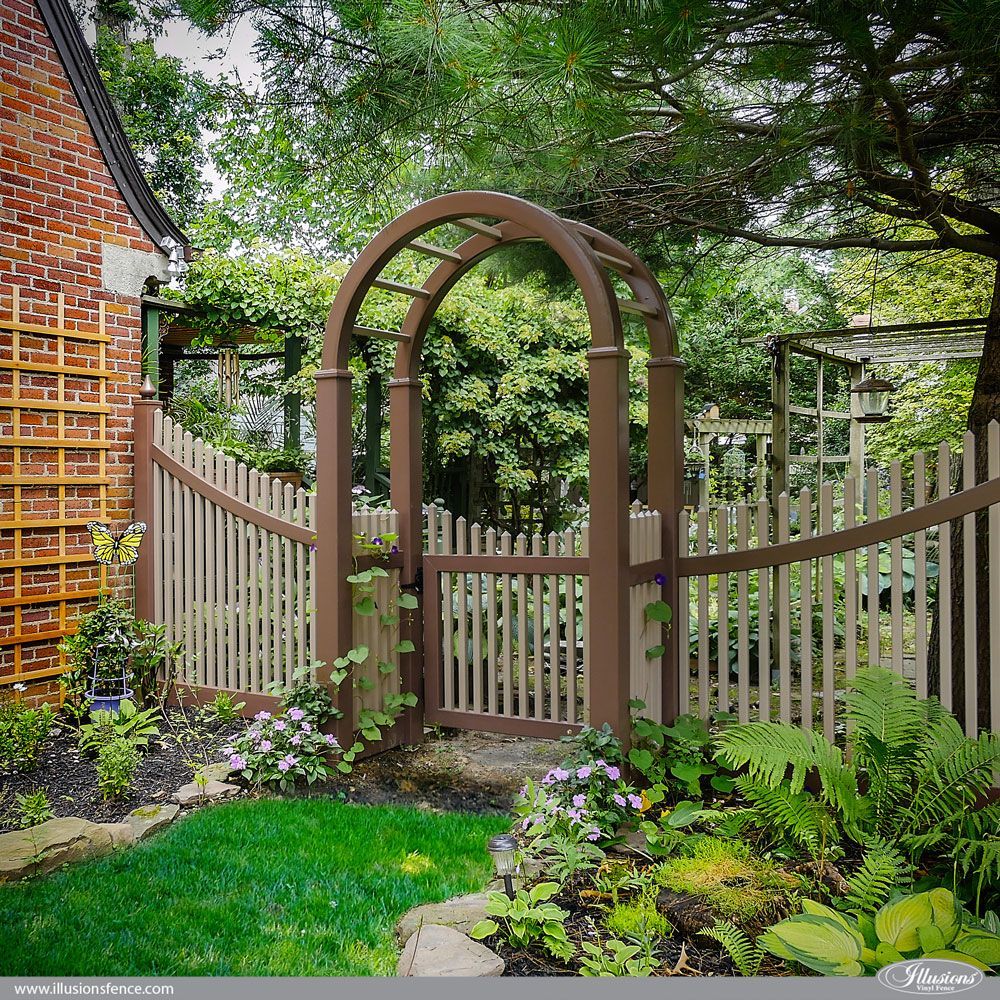 A garden with a wooden archway and a fence