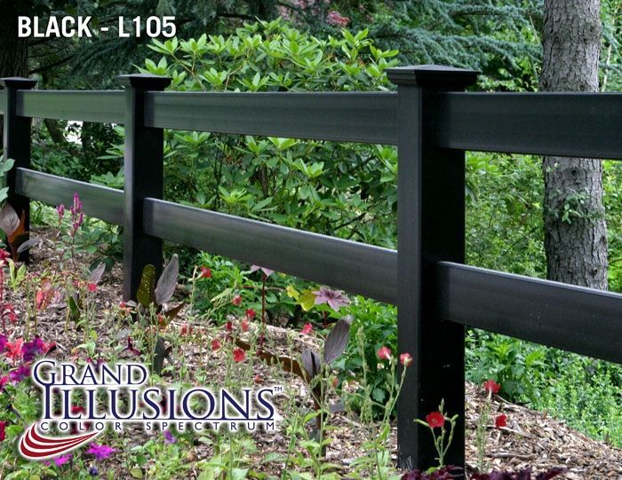 A black fence is surrounded by flowers and trees