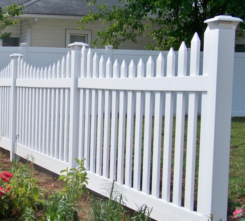 A white picket fence is in front of a house