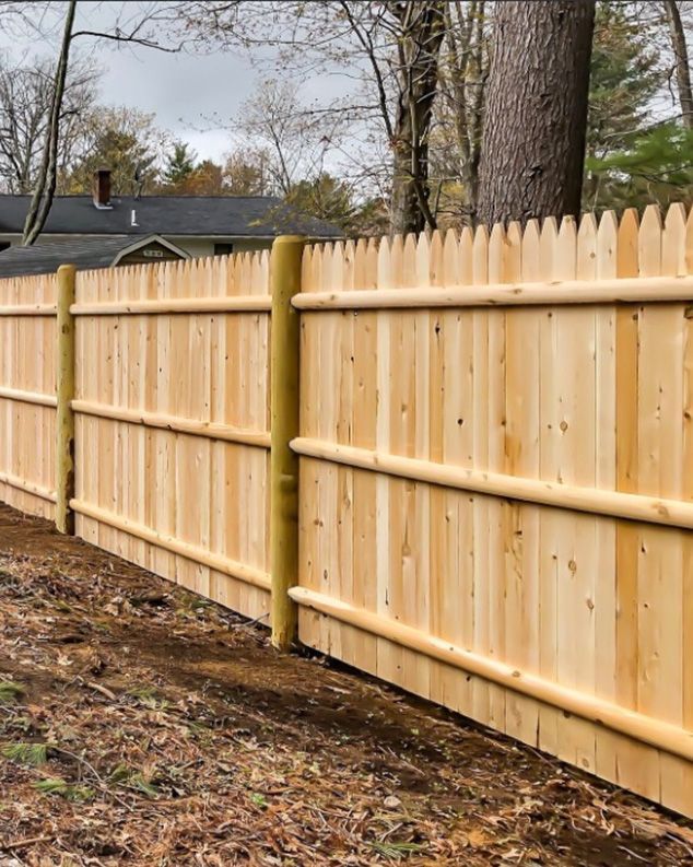A wooden fence with a house in the background