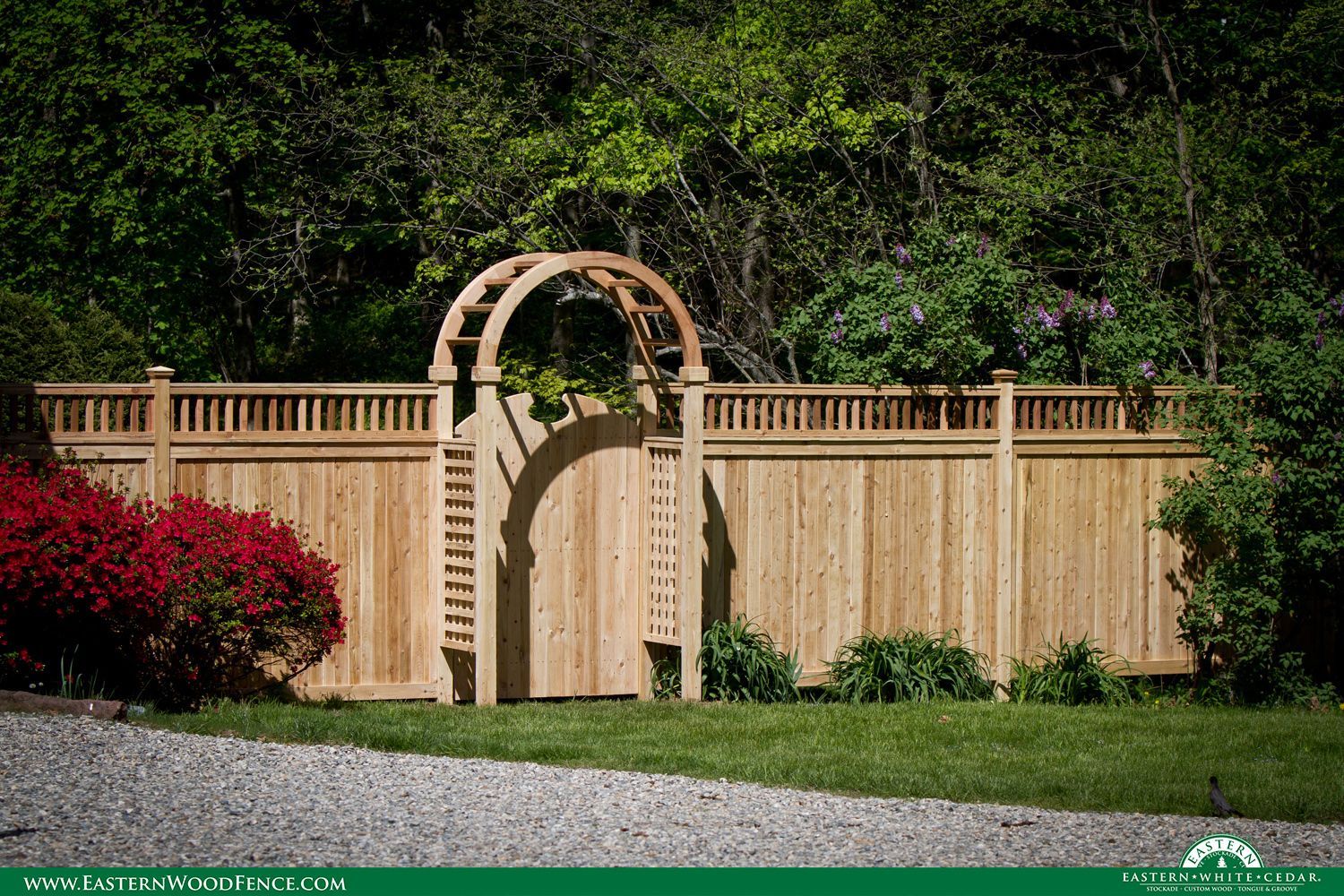 A wooden fence with a wooden arch in the middle of it