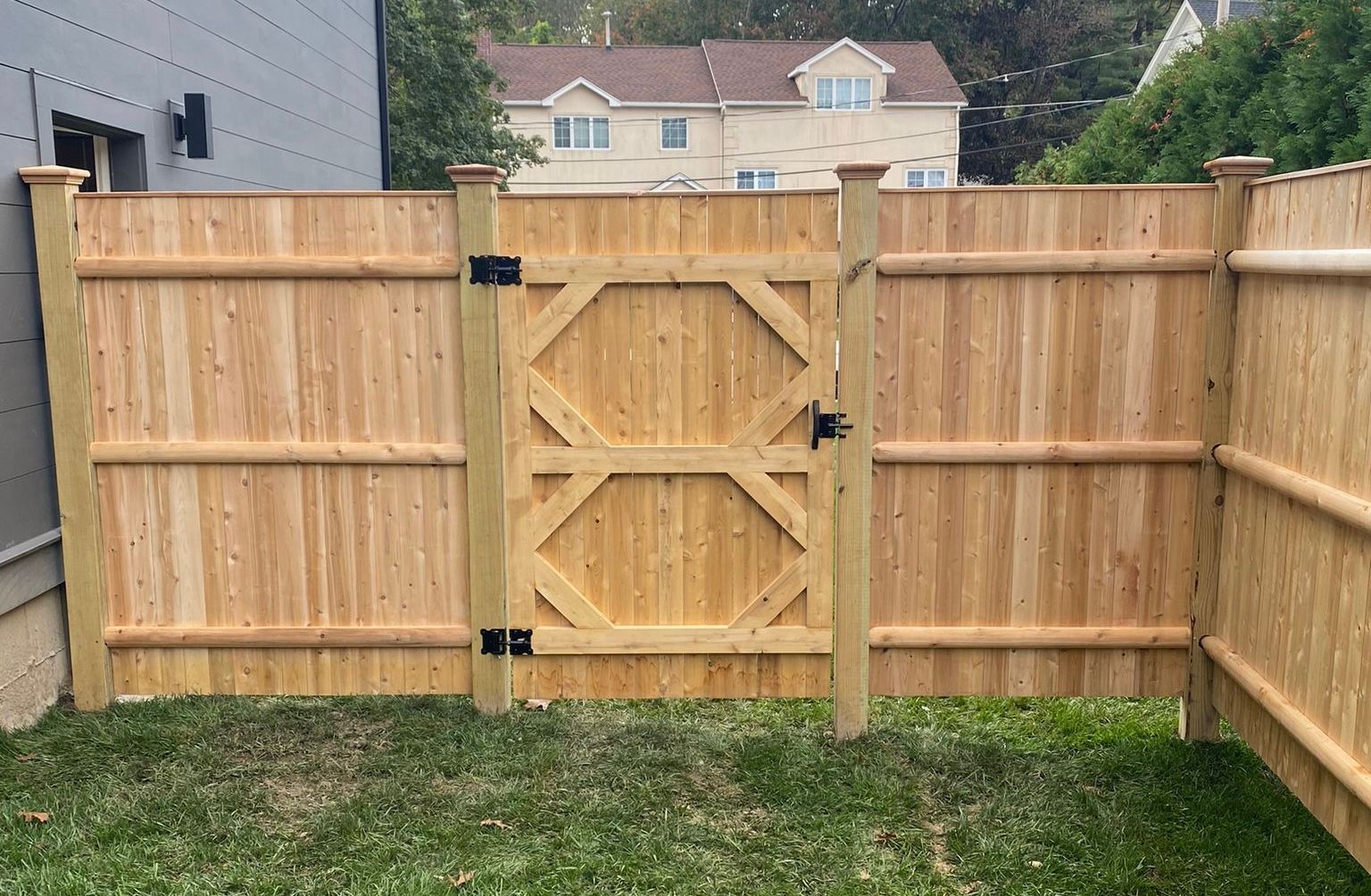 A wooden fence with a gate in the backyard.
