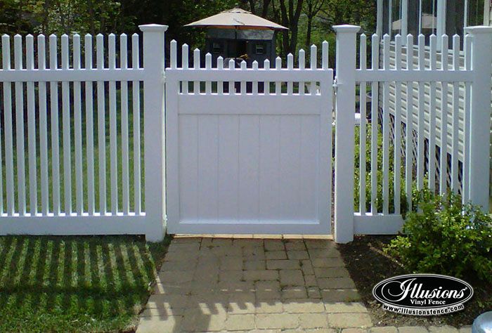 A white picket fence with a gate in front of it