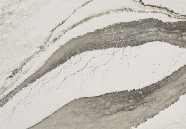 White countertop with flowing gray veining and minor cracks.
