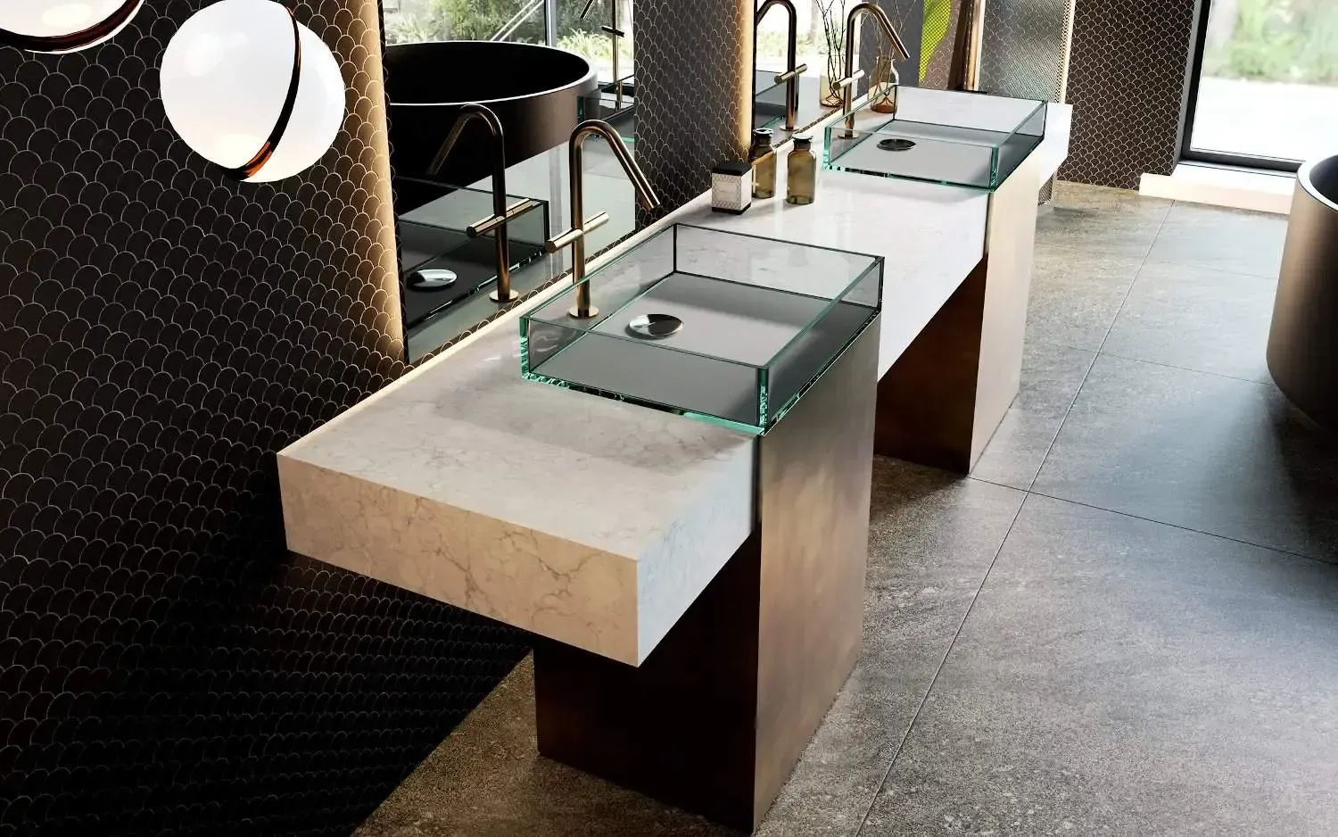 Bathroom with a long countertop, two glass sinks, gold faucets, and black tile wall.
