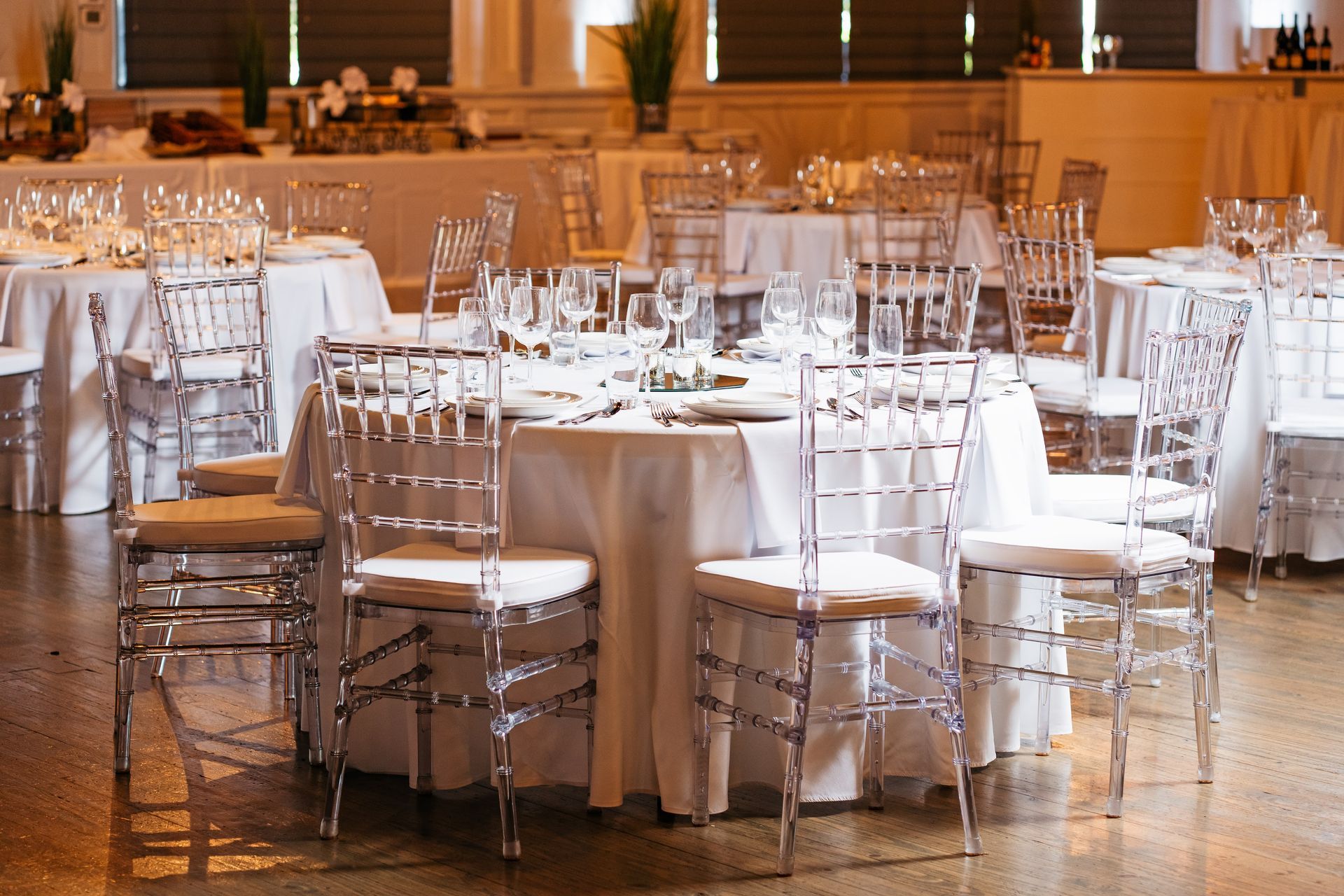 A large room with tables and chairs set up for a wedding reception