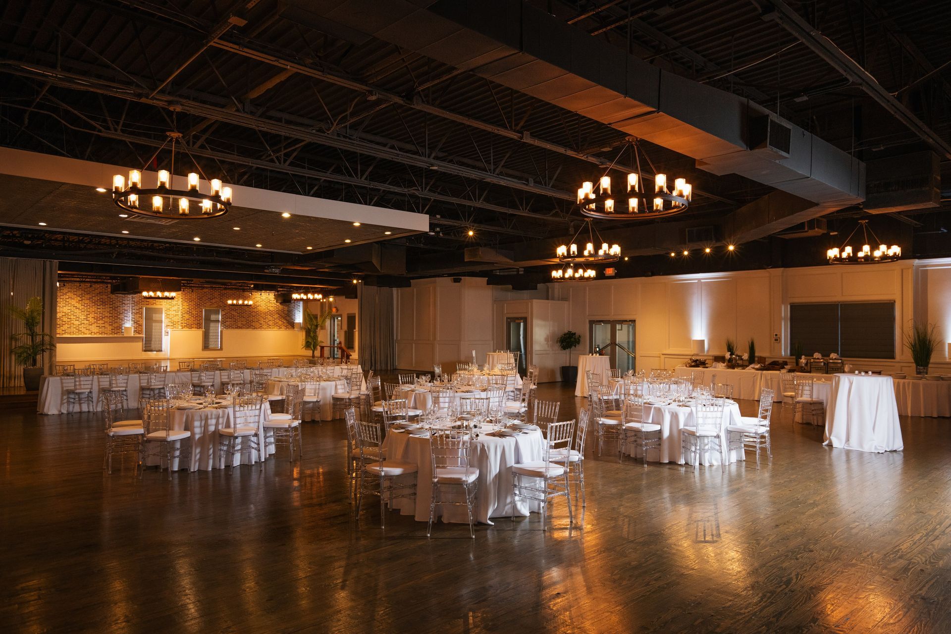 A large room with tables and chairs set up for a wedding reception.