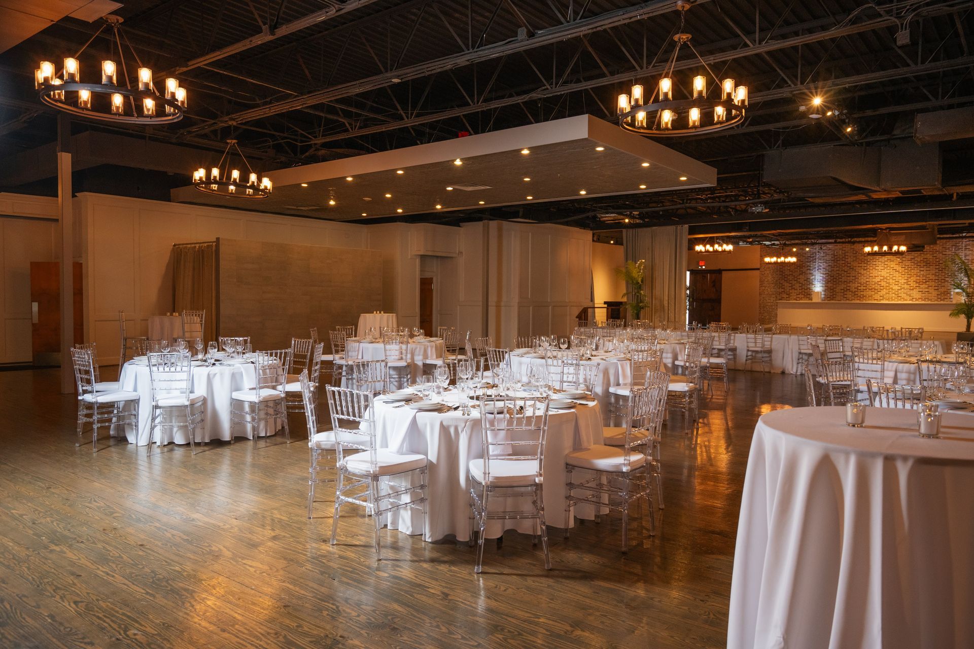 A large room with tables and chairs set up for a wedding reception.