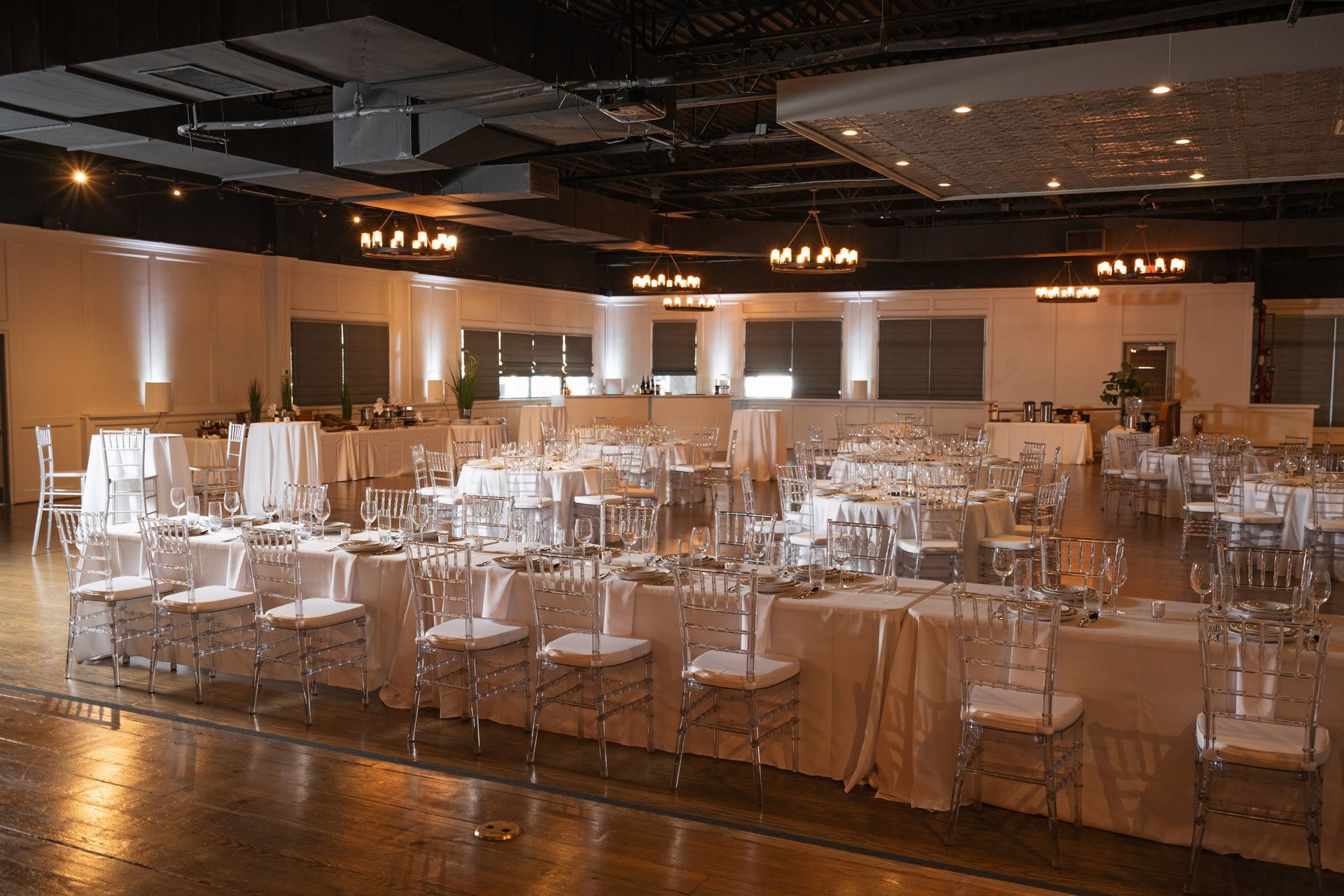 A large room with tables and chairs set up for a wedding reception.