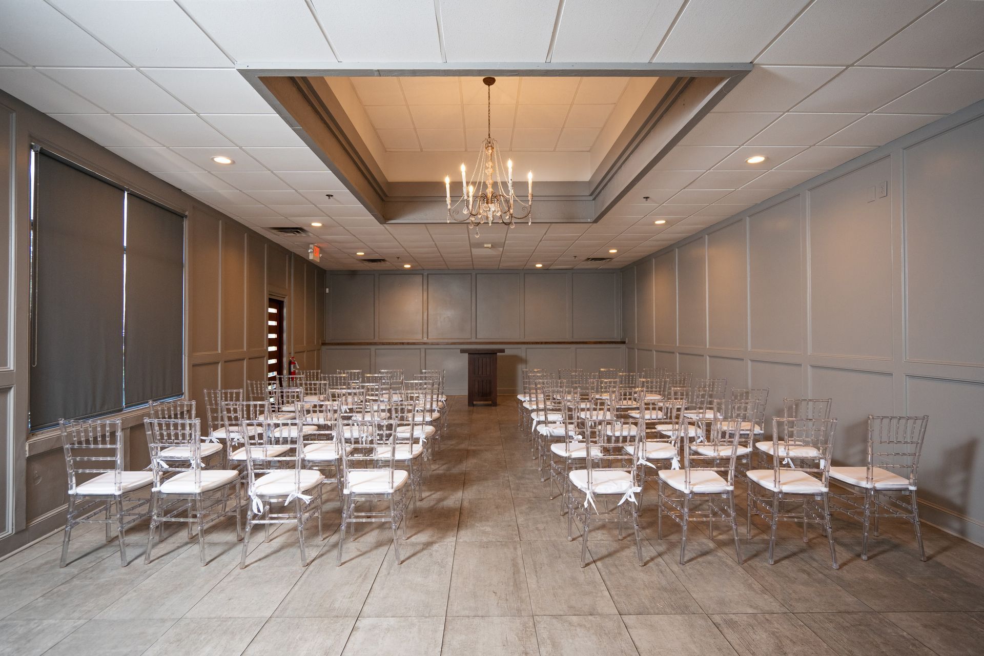 A large room with rows of chairs and a chandelier hanging from the ceiling.