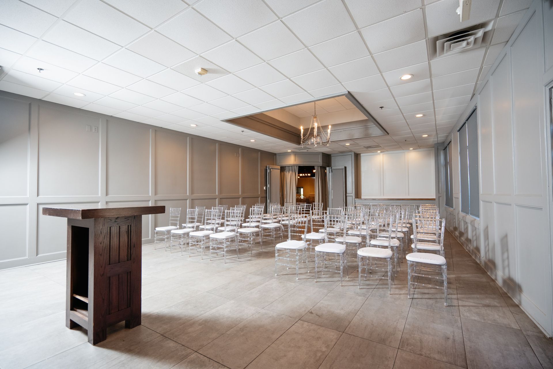 A large room with rows of chairs and a table in the middle.