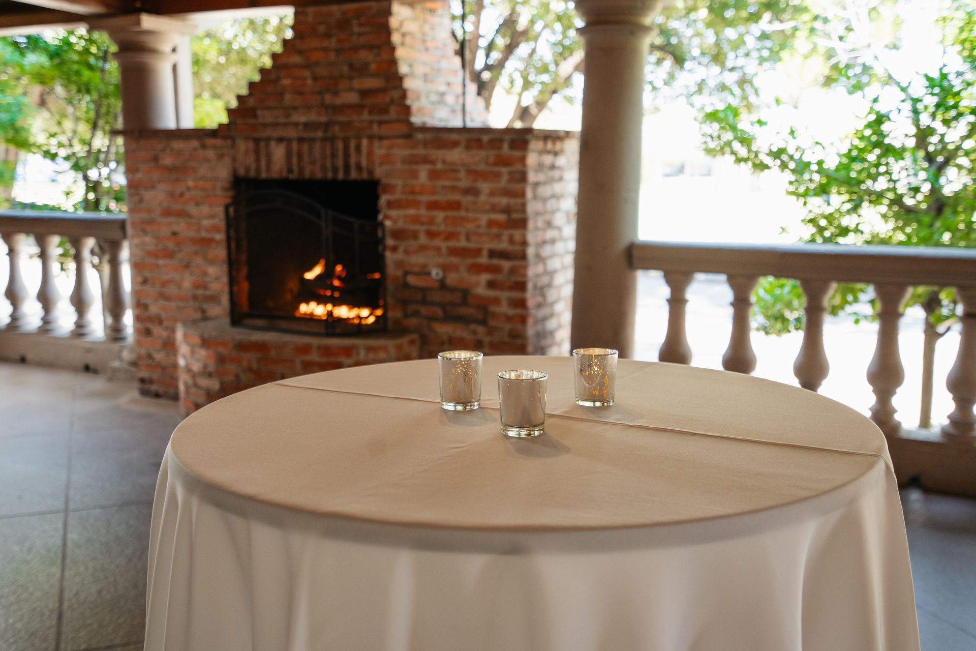 A table with two candles on it in front of a fireplace