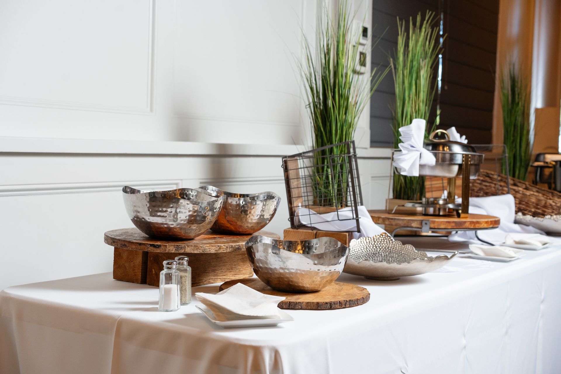 A buffet table with bowls and plates on it.
