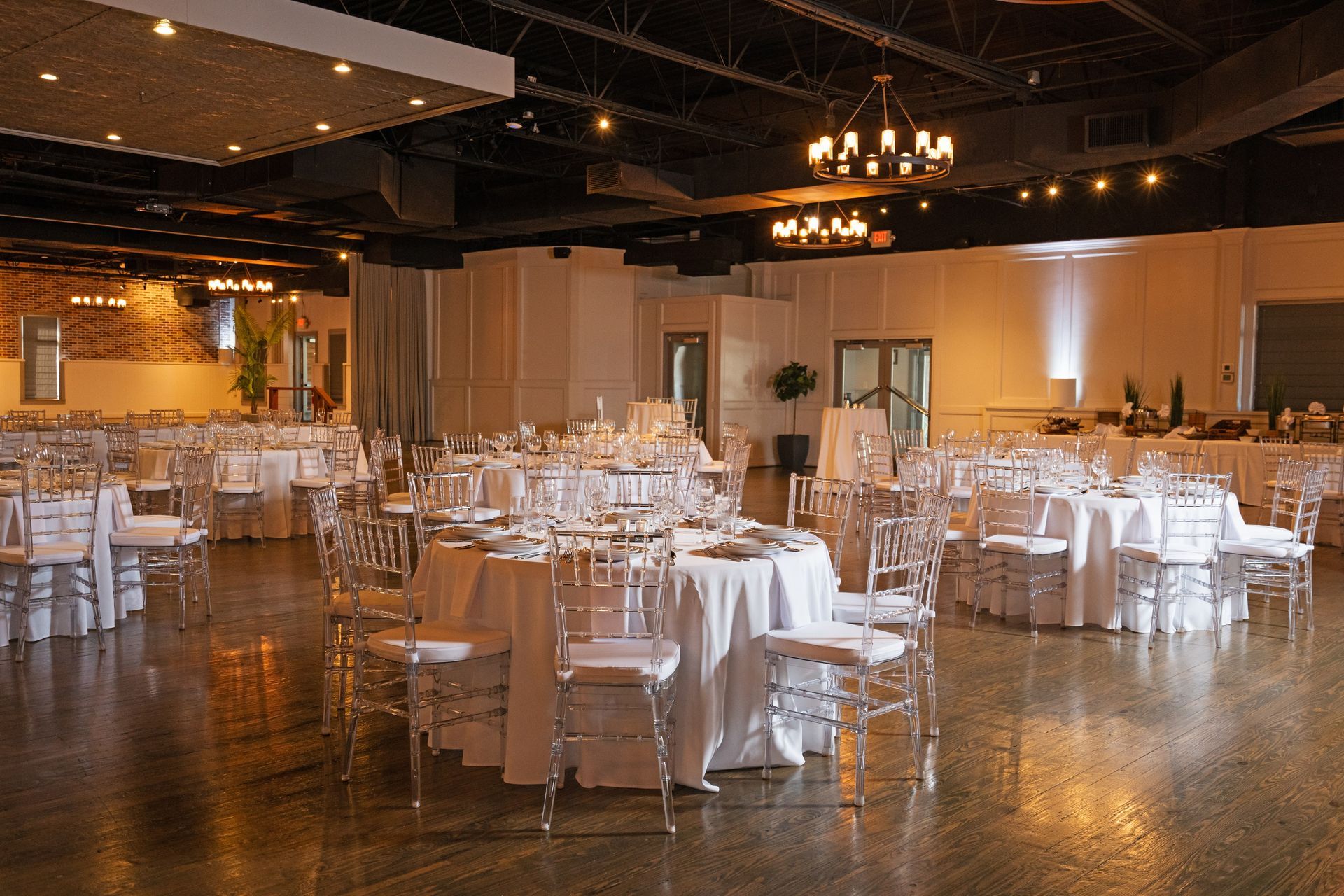 A large room with tables and chairs set up for a wedding reception