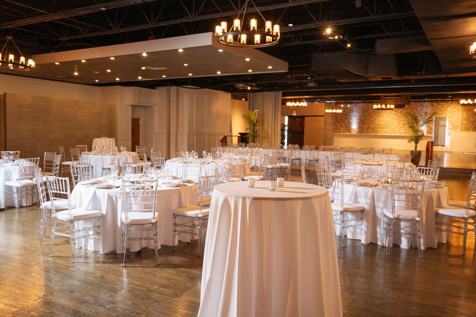 A large room with tables and chairs set up for a wedding reception