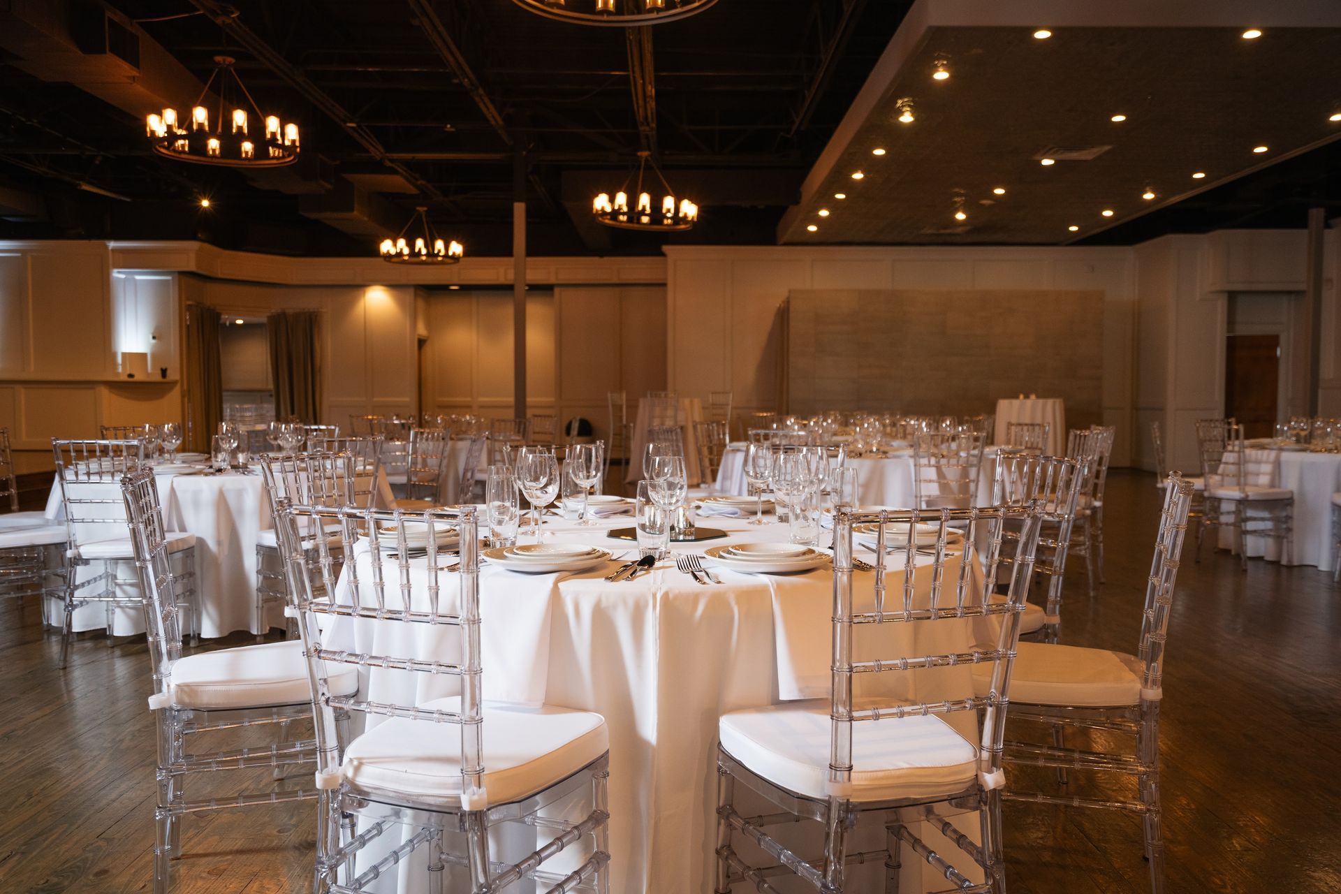 A large room with tables and chairs set up for a wedding reception.