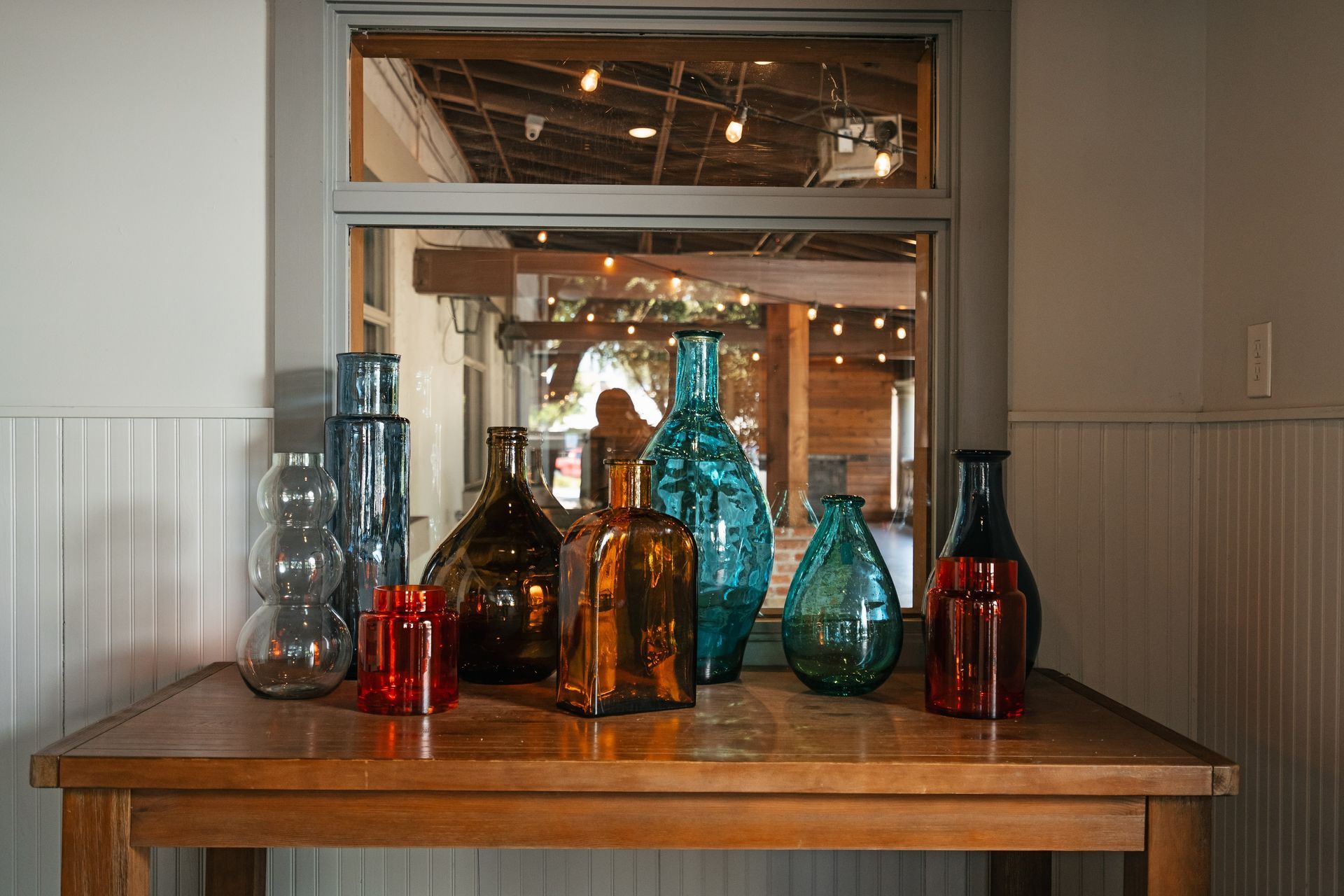 A wooden table with a bunch of vases on it.
