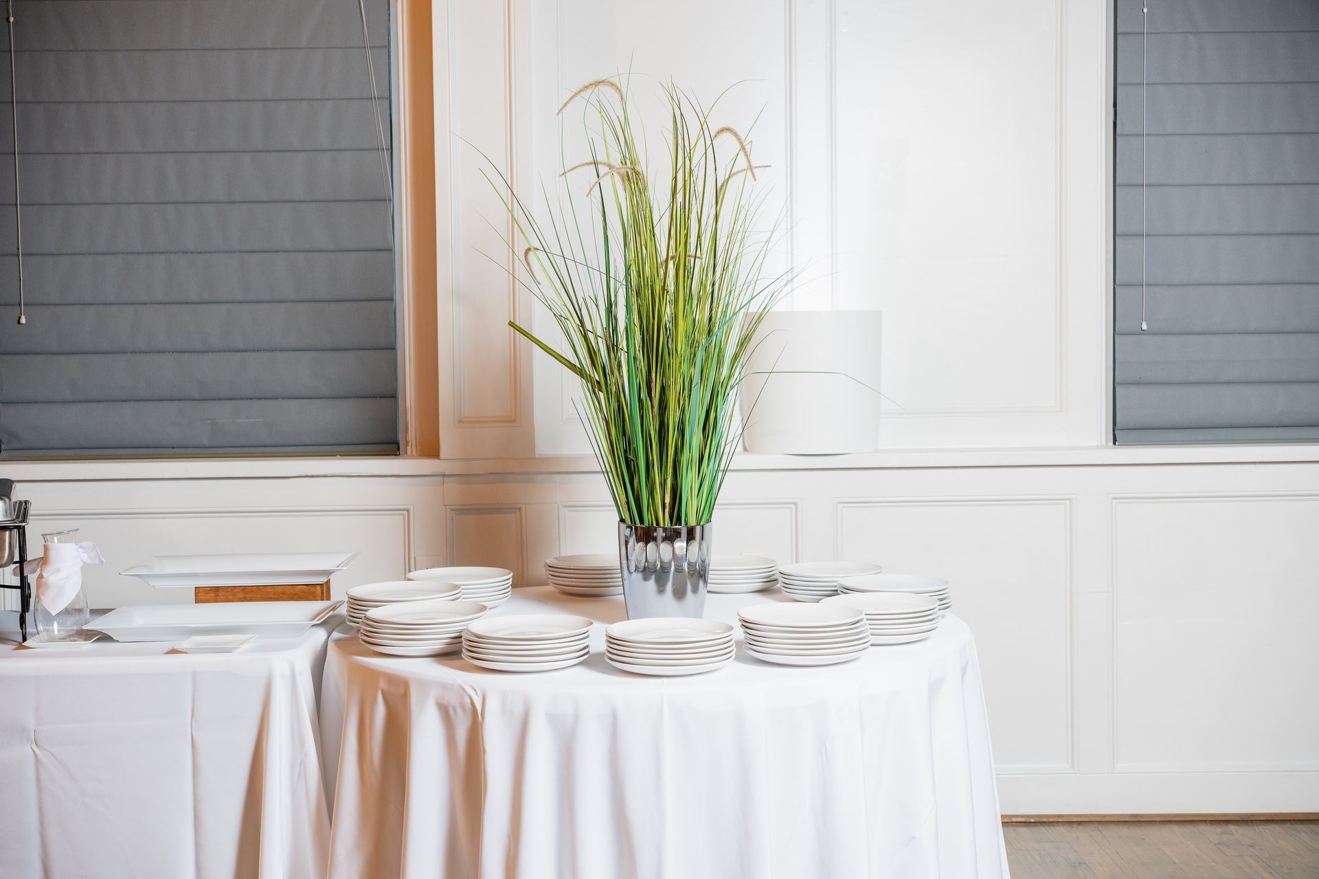 A table with a white tablecloth and a vase of flowers on it.
