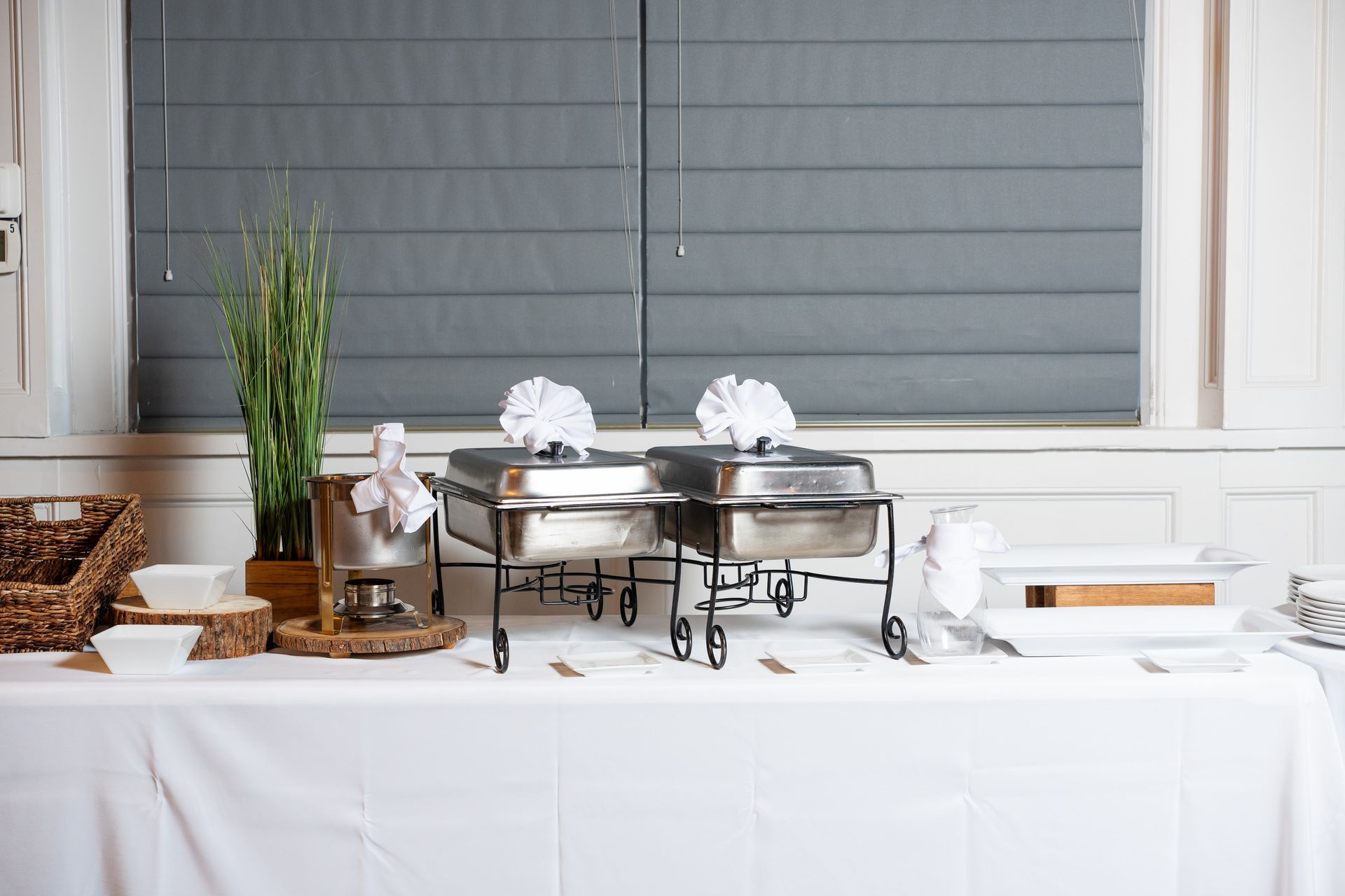 A buffet table with two stainless steel trays on it.
