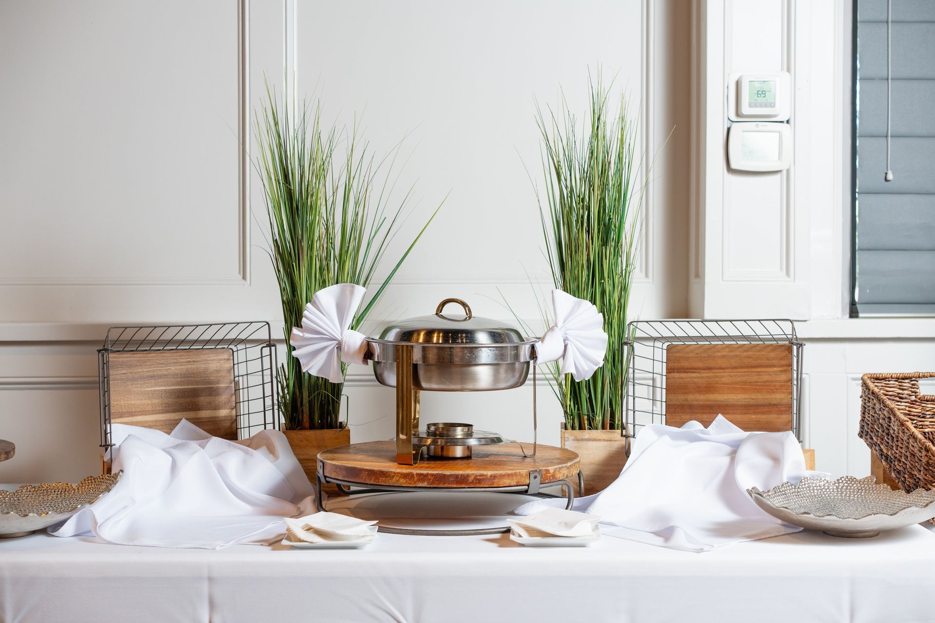 A buffet table with a stainless steel pot on top of it.
