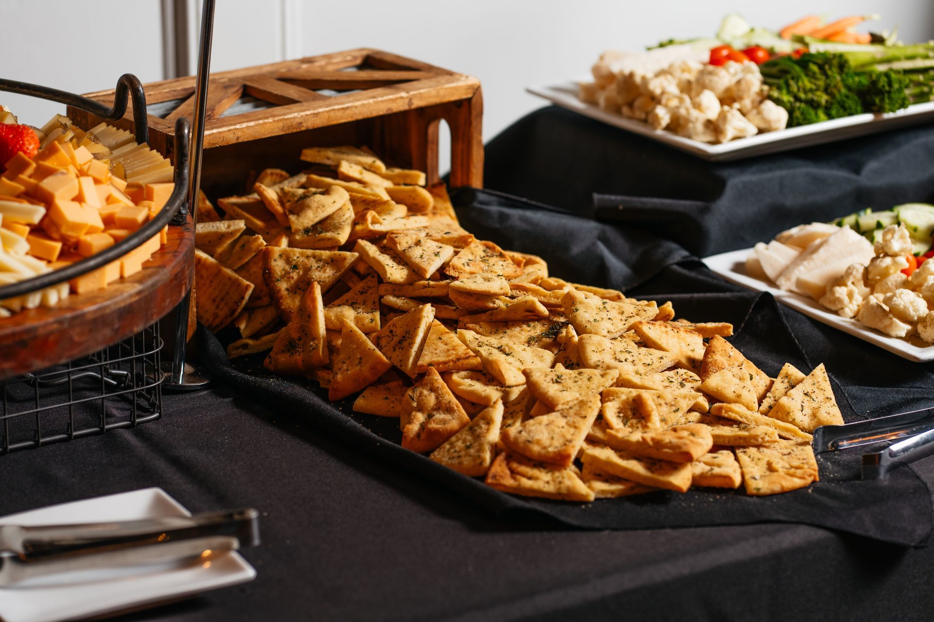 A buffet table with crackers and vegetables on it