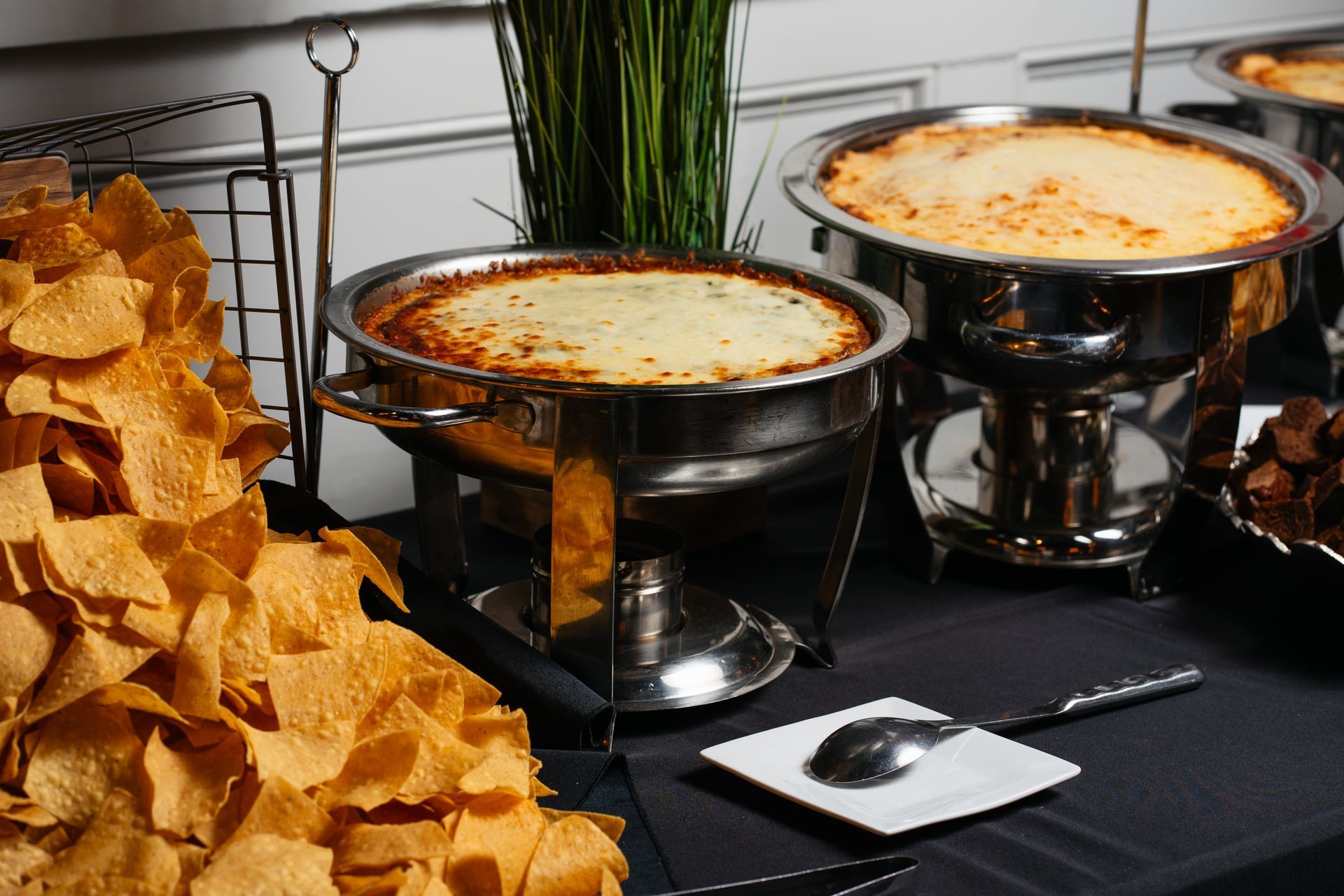A buffet table with tortilla chips and dips on it