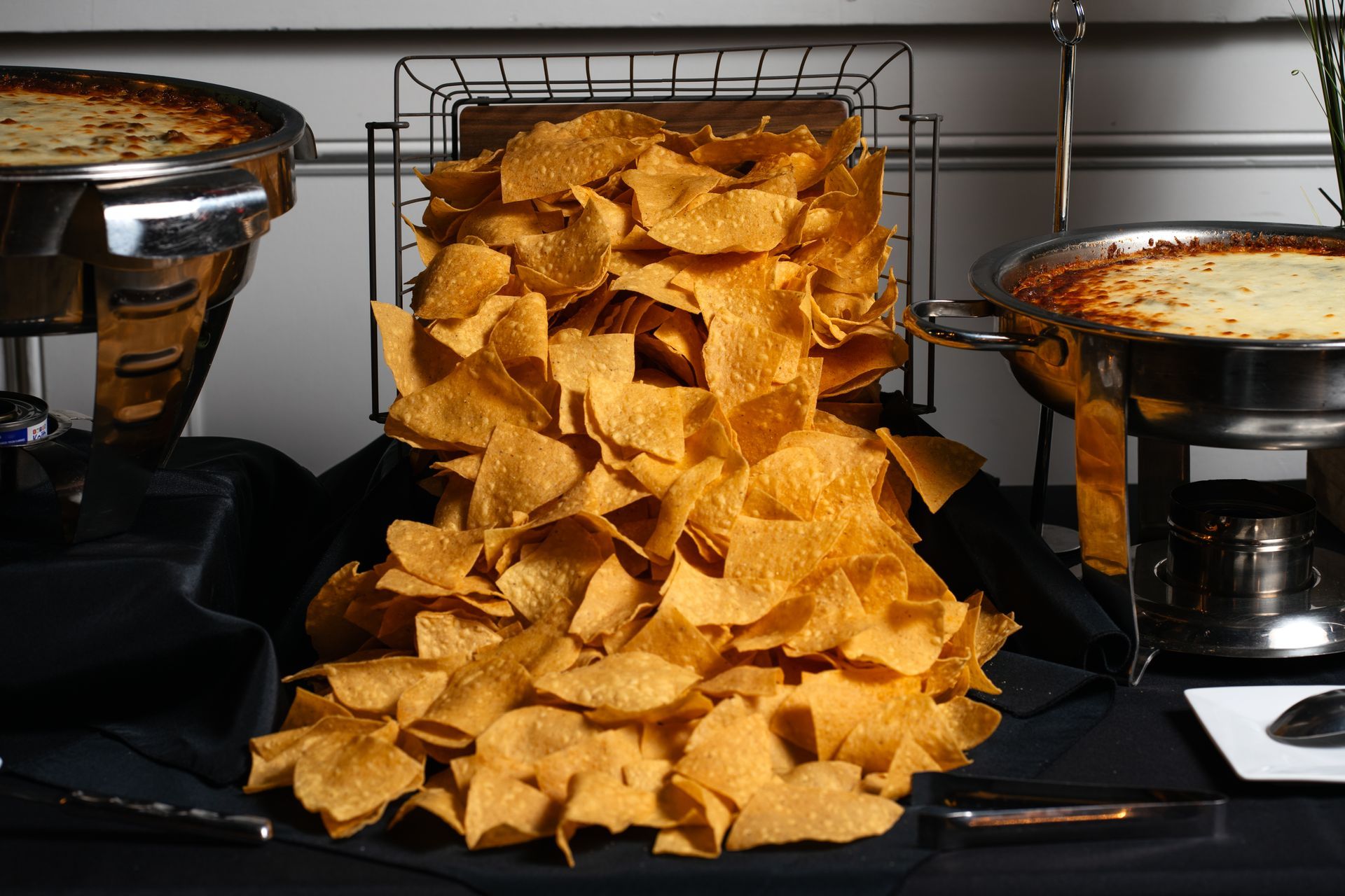 A large pile of tortilla chips is sitting on a table.