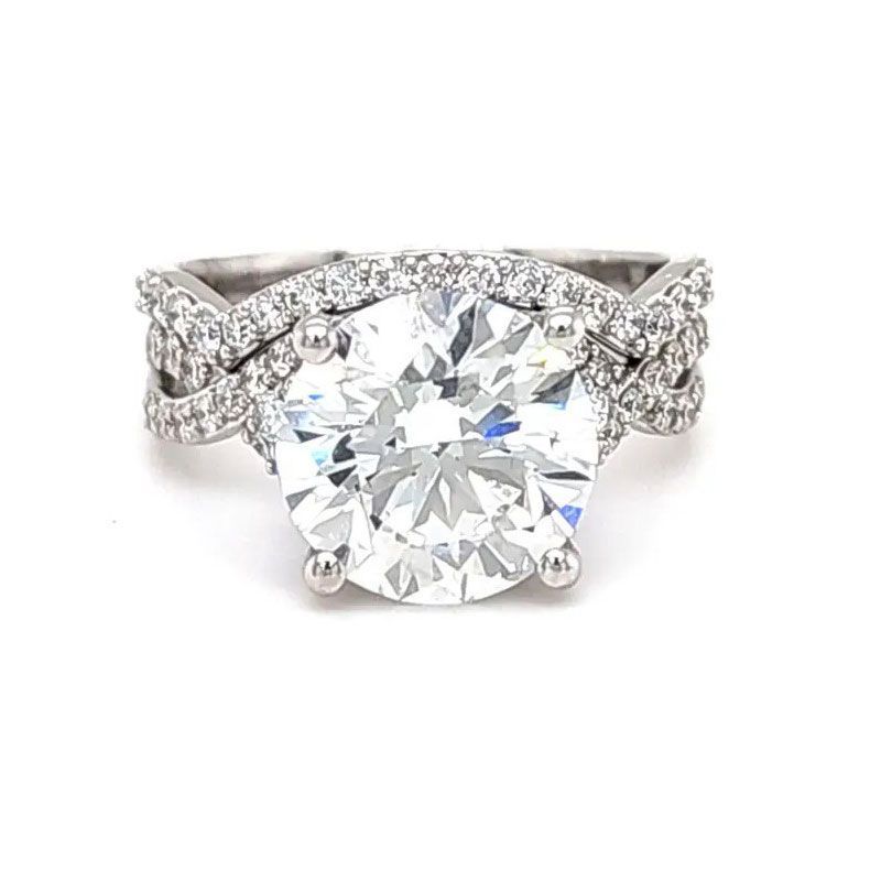Diamond engagement ring with large round center stone and pavé band on white background