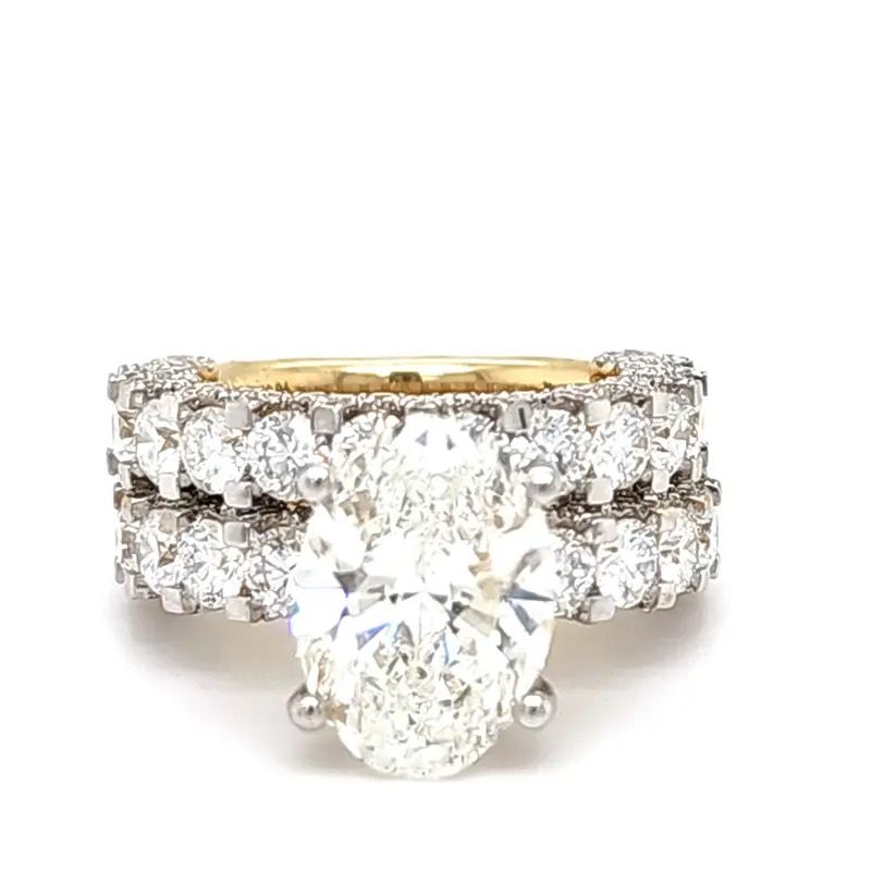 Diamond engagement ring with oval center stone and two pavé diamond bands on a white background