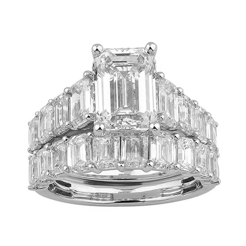 Three-stone diamond ring with emerald-cut center and baguette side stones on a white background