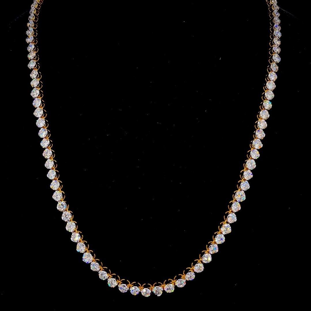 Delicate gold necklace with clear stones displayed on a black background